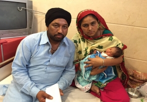 Parents holding their newborn with the care team